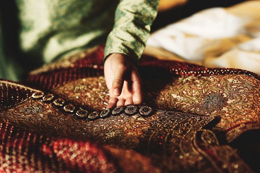 Groom in green shirt touches his red sherwani Empowering Rural Artisans and the Indian Silk Ecosystem